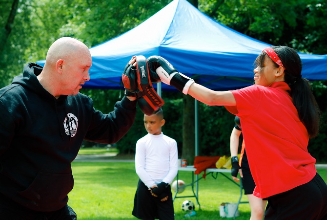 A young girl learns how to box with an instructor at a Community Games event