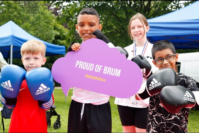 Group of young children holding "proud of Brum" poster