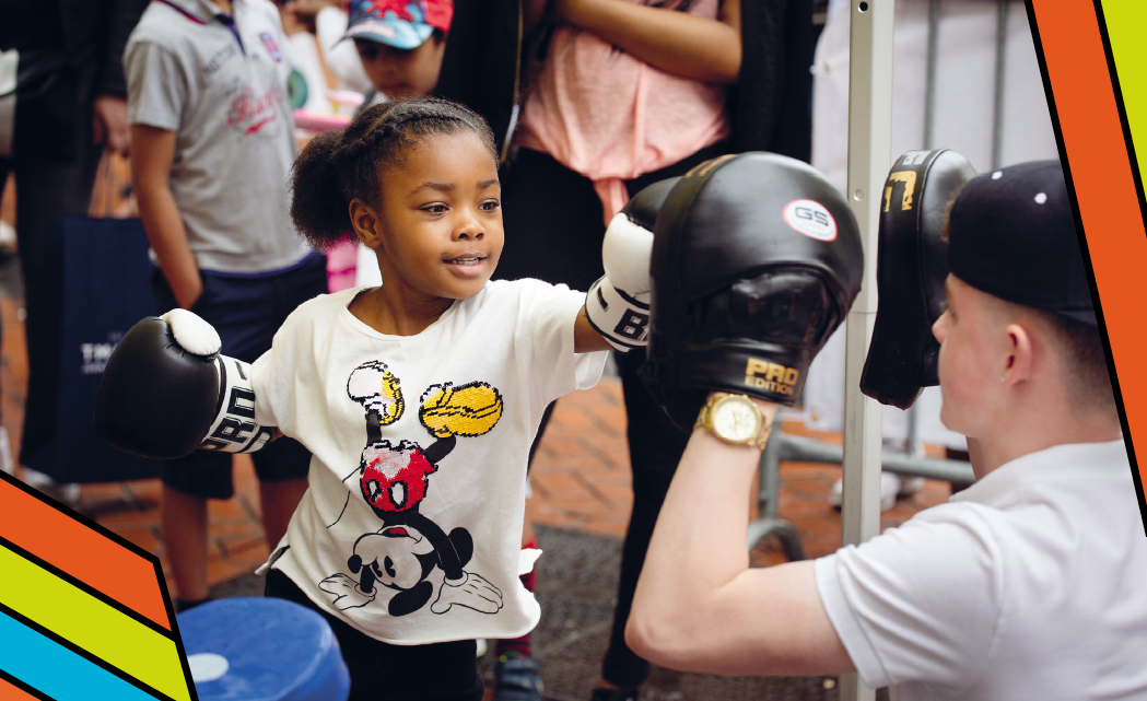 Young child sparring with a boxing instructor