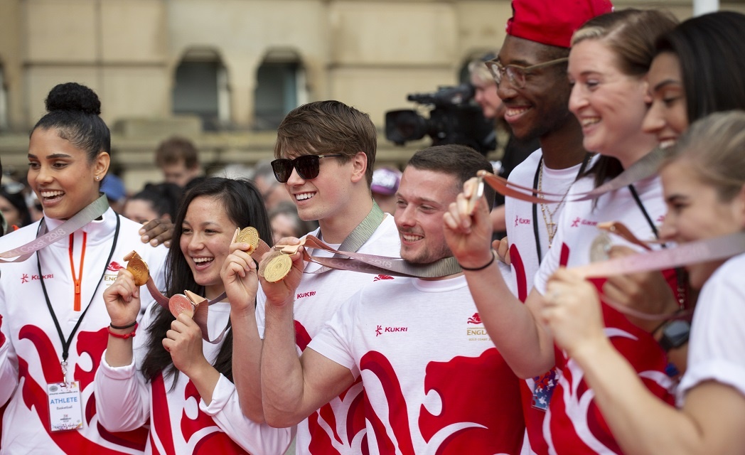 Group of England athletes holding up medals