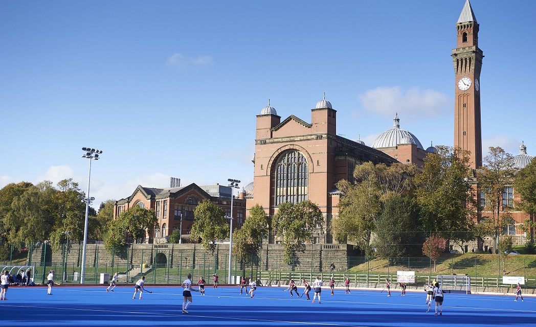 Outdoor hockey match taking place in front of several buildings