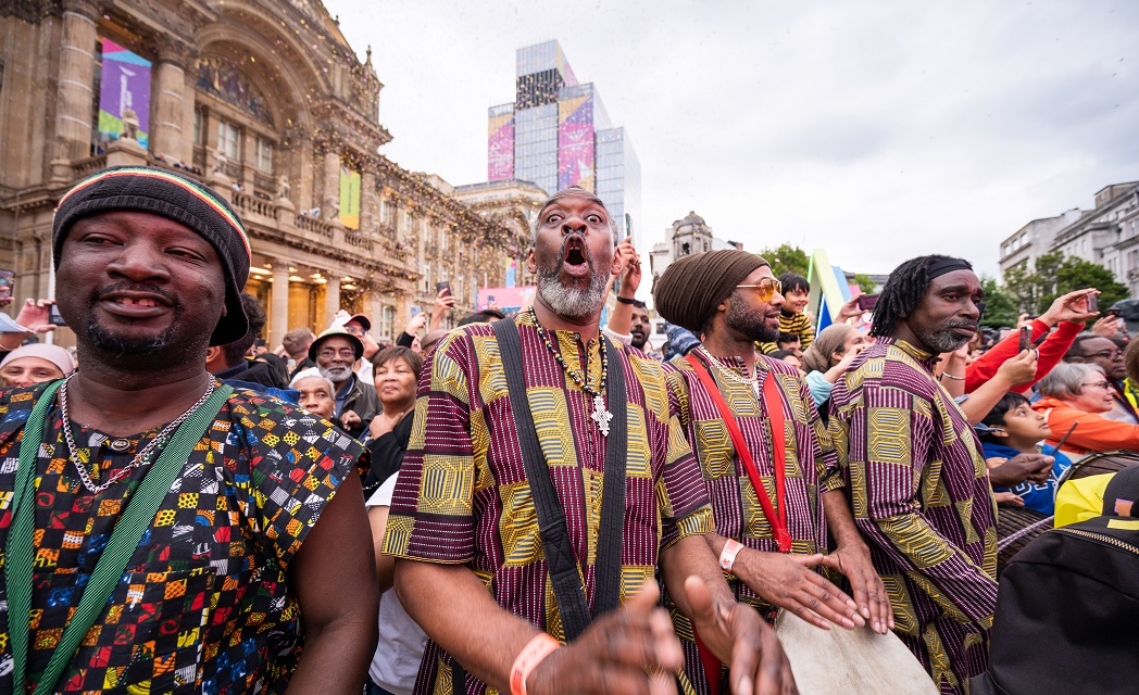 Community drummers lead a crowd of people in Victoria Square to welcome the arrival of the Queen's Baton Relay