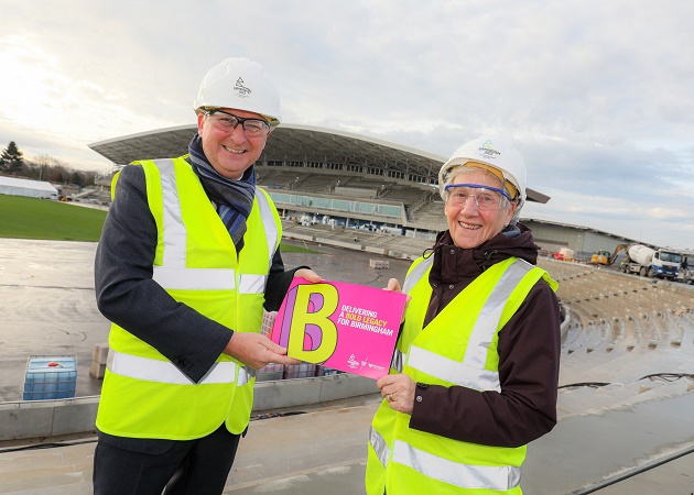 Cllr Ian Ward, Leader of Birmingham City Council and Dame Louise Martin, President of the Commonwealth Games Federation, hold a copy of Delivering a Bold Legacy for Birmingham at the Alexander Stadium