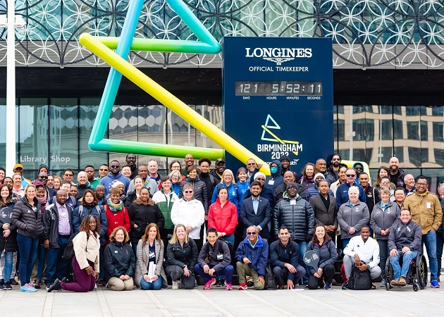 Delegates representing 58 Commonwealth nations and territories outside the Countdown Clock in Centenary Square, Birmingham