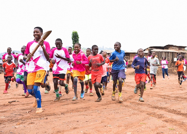 A group of children carry the Queen’s Baton in Uganda